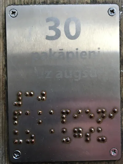 A silver sign with silver letters.